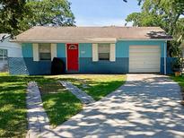 Charming one-story home with a bright red front door and attached garage at 818 Alabama Ave, St Cloud, FL 34769