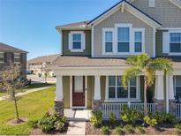 Charming two-story townhome with a welcoming front porch and landscaped yard at 9971 Highland Sky Aly, Orlando, FL 32832