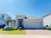 Charming single-story home with a brick driveway and well-manicured lawn at 1009 Hendon Loop, Davenport, FL 33837