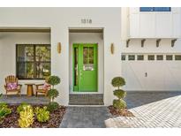 Close-up of modern home's entrance, showcasing a vibrant green door and elegant landscaping at 1018 Stetson St, Orlando, FL 32804