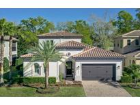 Charming two-story home with a tile roof, manicured landscaping, and a two-car garage, showcasing its desirable curb appeal at 1377 Tappie Toorie Cir, Lake Mary, FL 32746