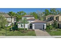 Charming single-Gathering home features a well-manicured lawn, gray garage door, and beautiful landscaping at 1377 Tappie Toorie Cir, Lake Mary, FL 32746