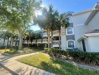 Attractive condo complex featuring multi-story balconies, lush trees, and well-maintained landscaping at 13827 Fairway Island Dr # 1232, Orlando, FL 32837