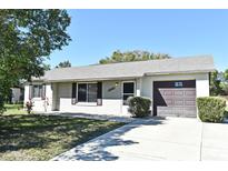 Charming single-story home with a well-maintained front yard and attached garage at 1389 Rural Hall St, Deltona, FL 32725