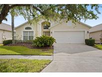 Inviting single-story home featuring lush landscaping and a two-car garage at 155 Barefoot Beach Way, Kissimmee, FL 34746