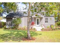 Charming home featuring manicured landscaping, a cozy porch and fresh, neutral paint at 1855 Cloverlawn Ave, Orlando, FL 32806