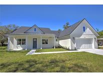 Charming home featuring a well-manicured lawn and classic architectural details at 216 Homewood Dr, Sanford, FL 32773