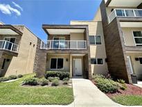 Modern two-story townhome featuring a balcony, neutral tones, and manicured landscaping at 3191 Brasilia Ave, Kissimmee, FL 34747