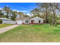 Charming single-story home featuring brick accents, a well-maintained lawn, and a classic red front door at 3357 Shalimar Cir, Deltona, FL 32738