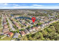 A beautiful aerial view showcases the lovely homes and community in this neighborhood with pond and trees at 4655 Ross Lanier Ln, Kissimmee, FL 34758