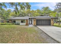 Charming home featuring stone accents, lush landscaping, and a two-car garage at 5374 Crooked Oak Cir, St Cloud, FL 34771