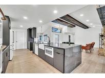 Open concept kitchen features a large island, modern appliances, and wood floors throughout the living space at 5374 Crooked Oak Cir, St Cloud, FL 34771