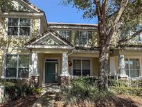 Charming two-story townhome with a welcoming porch, decorative columns, and well-maintained landscaping at 7407 Ripplepointe Way, Windermere, FL 34786