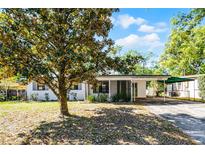 Charming single-story home with a covered carport and well-maintained front yard landscaping at 818 Logan Dr, Longwood, FL 32750