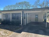 Charming single-story home with a covered carport, screened porch, and well-maintained front yard at 818 Logan Dr, Longwood, FL 32750