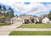 Charming single-story home featuring a well-manicured lawn and a two-car garage at 872 High Pointe Cir, Minneola, FL 34715