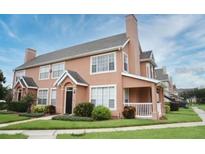 View of a well-maintained two-story townhouse with lush lawn and manicured landscaping on a sunny day at 9093 Lee Vista Blvd # 905, Orlando, FL 32829