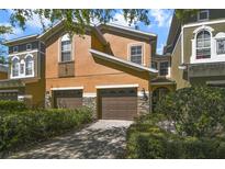 Two-story townhome featuring an attached two car garage, neutral paint, and manicured front yard at 9236 Sweet Maple Ave, Orlando, FL 32832