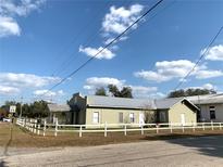 Charming one-story home with a new metal roof and a white picket fence at 100 John St, Frostproof, FL 33843