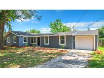 Charming single-story home featuring an attached garage and well-maintained lawn at 10607 Allisheim Ave, Orlando, FL 32825