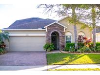 Charming single-story home with stone accents, a well-maintained lawn, and mature landscaping at 10942 High Bush Ct, Orlando, FL 32825