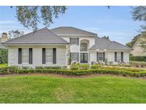 Beautiful two-story home features a manicured front lawn, a tile roof, and lush landscaping at 142 Stone Hill Dr, Maitland, FL 32751