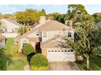 Charming two-story home with a well-manicured lawn and a two-car garage at 1751 Meadowgold Ln, Winter Park, FL 32792