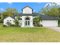 Charming two-story home with a well-manicured lawn and tropical landscaping at 30912 Fairvista Dr, Tavares, FL 32778