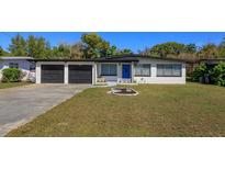 Charming one-story home with a well-manicured lawn and a bright blue front door, enhancing curb appeal at 427 Zimmerman Dr, Orlando, FL 32839