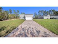 Beautiful new construction home featuring a brick driveway and a two-car garage at 17135 Sw 41 Ct, Ocala, FL 34473