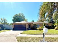 Beautiful home showcasing a spacious driveway, attached garage, and lush front lawn at 5132 Goldenrod Place Rd, Winter Park, FL 32792