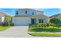 Charming two-story home featuring a well-manicured lawn and attached two-car garage at 5709 Sagunto Dr, Davenport, FL 33897