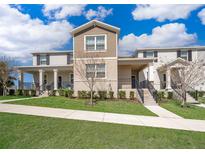 A townhome showcases a manicured lawn and a sidewalk that leads up to the front door at 9951 Alliteration Aly, Winter Garden, FL 34787