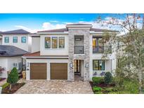 Stunning two-story home with stone accents, balcony, two-car garage, and a beautifully landscaped front yard at 1003 Jack Nicklaus Ct, Kissimmee, FL 34747