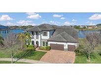 Stunning two-story home with a tile roof, two-car garage, well-manicured lawn, and partial lake view at 16629 Broadwater Ave, Winter Garden, FL 34787