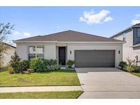 Charming single-story home featuring a well-manicured lawn and an attached two-car garage at 1773 Groveline Rd, St Cloud, FL 34771