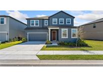 Charming two-story home with a well-manicured lawn and attached two-car garage at 2099 Derwent Dr, Davenport, FL 33896