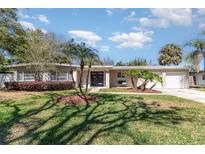Charming single-story home featuring a well-manicured lawn, a two-car garage, and tasteful landscaping at 2335 Coldstream Dr, Winter Park, FL 32792