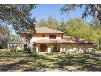 Charming two-story home featuring a terracotta tile roof, arched entryways, and a well-manicured lawn at 275 Clearview Rd, Chuluota, FL 32766