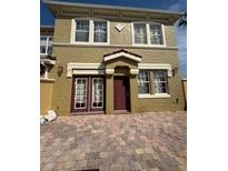Two-story townhome with a brick driveway and classic architectural details at 3026 Bella Vista Dr, Davenport, FL 33897
