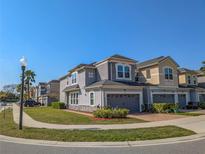 Charming townhome with neutral gray paint, well-manicured lawn, and attached garages in a friendly neighborhood at 3593 Brighton Park Cir, Belle Isle, FL 32812