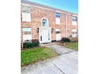 Two-story brick condo building with a white front door and manicured landscaping at 4268 Lake Underhill Rd # 4, Orlando, FL 32803