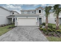 Charming two-story home featuring a two-car garage, lush landscaping and a welcoming front entrance at 7376 Oakmoss Loop, Davenport, FL 33837