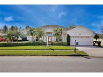 Charming single-story home featuring a well-manicured lawn, mature palm trees, and a brick driveway at 9102 Shadowbrook Trl, Orlando, FL 32825