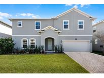 Charming two-story home featuring a well-maintained lawn and a two car garage with a brick paver driveway at 965 Talon Pl, Winter Springs, FL 32708