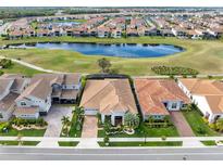 A beautiful aerial view shows the tile roofs and backyard lake views of this luxury home at 13346 Alderley Dr, Orlando, FL 32832