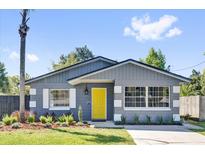 Charming home featuring a gray exterior, bright yellow front door, and meticulously landscaped yard at 1708 Melvin Ave, Orlando, FL 32806