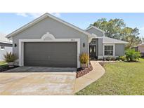 Charming single-story home with a two-car garage, well-manicured lawn, and inviting front entrance at 2511 Chatham Cir, Kissimmee, FL 34746