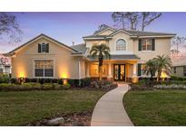 Elegant home featuring a well-manicured lawn, lush landscaping, and a welcoming walkway to the front entrance at 3352 Park Grove Ct, Longwood, FL 32779