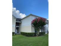 Exterior view of the condo with a large leafy tree in front of a screened patio on a sunny day at 3960 Southpointe Dr # 503, Orlando, FL 32822